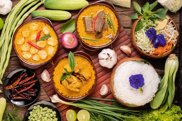 Free photo rice noodles in a bowl of curry paste with chili, cucumber, long bean, lime, garlic and spring onion