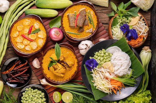 Free Photo rice noodles in a bowl of curry paste with chili, cucumber, long bean, lime, garlic and spring onion