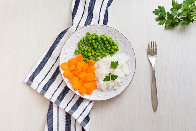 Rice with vegetables and parsley on plate 