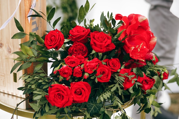 Rich bouquet made of red roses stands outside 