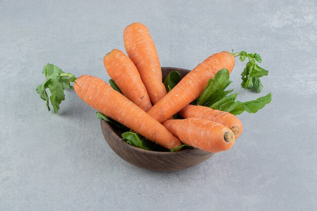 Ripe carrots in the bowl , on the marble.