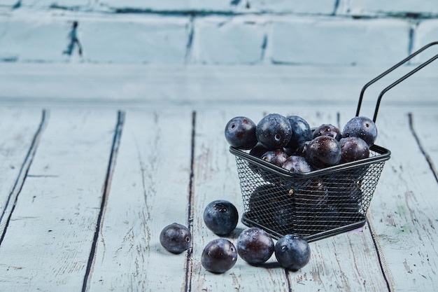 Ripe garden plums on blue table.