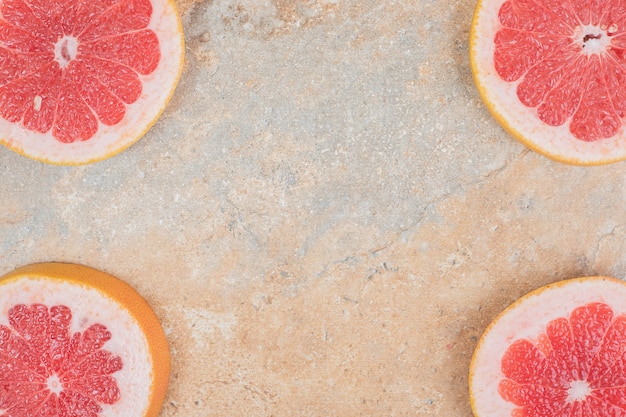 Ripe grapefruit slices on marble surface. High quality photo