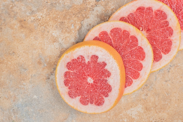 Free photo ripe grapefruit slices on marble surface.