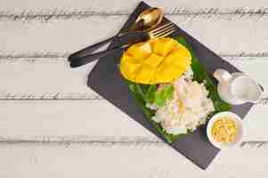 Free photo ripe mango and sticky rice with coconut milk on stone surface, thai sweet dessert on summer season.