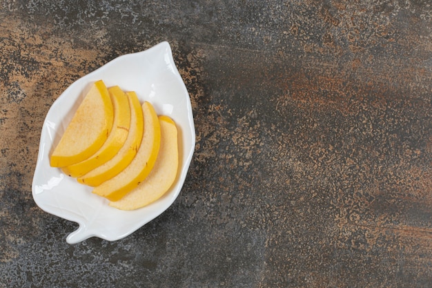 Ripe sliced quince on leaf shaped plate