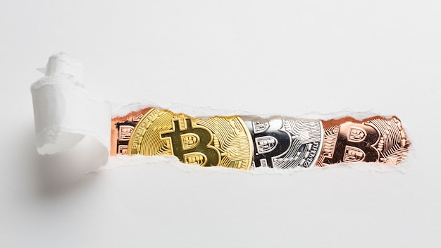 Free photo ripped paper revealing bitcoin