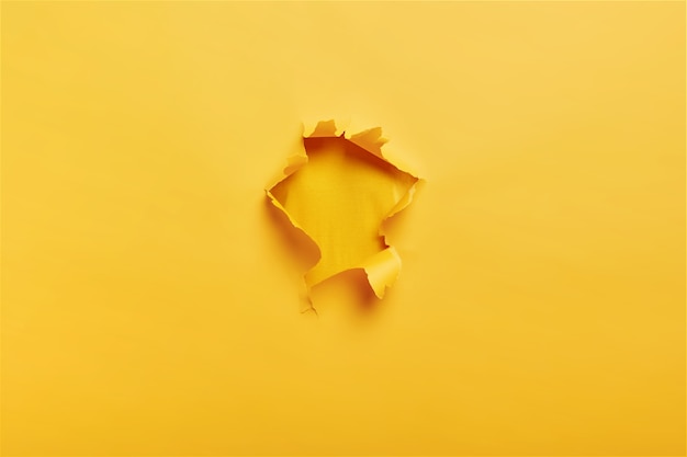 Ripped torn yellow paper with hole in center