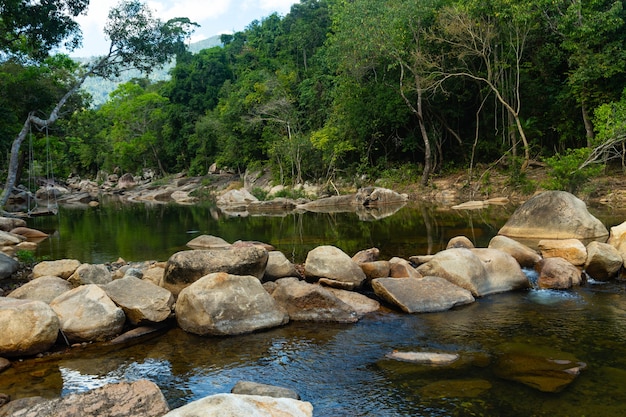 River in the middle of rocks and trees at Ba Ho Waterfalls Cliff in Vietnam