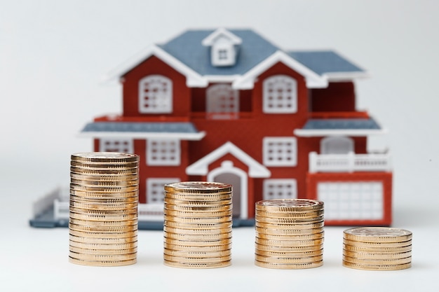 Free photo rmb coins stacked in front of the housing model (house prices, house buying, real estate, mortgage concept)