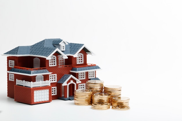 Free photo rmb coins stacked in front of the housing model (house prices, house buying, real estate, mortgage concept)