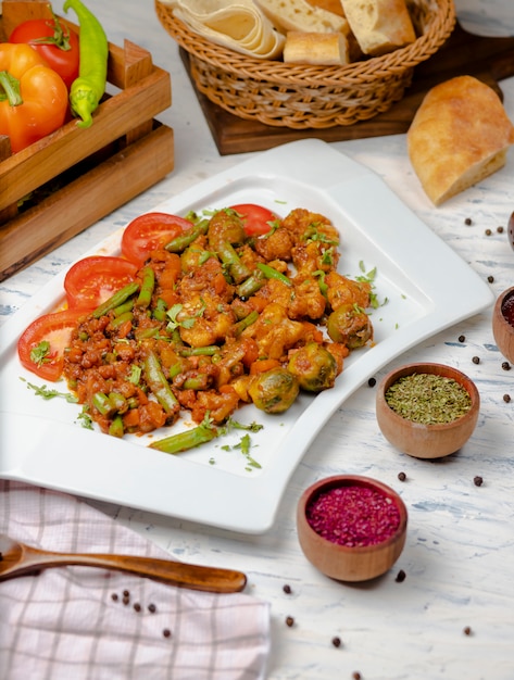 Roasted cauliflower with sprouts, beans and served with tomato sauce and herbs