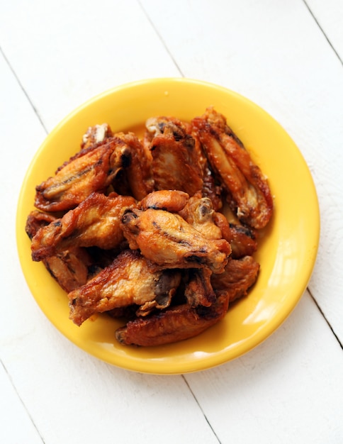 Free photo roasted chicken wings in a yellow bowl