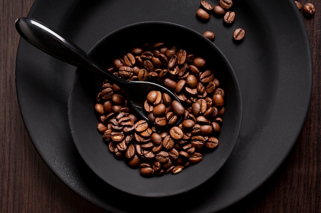 Free photo roasted coffee beans in bowl with spoon