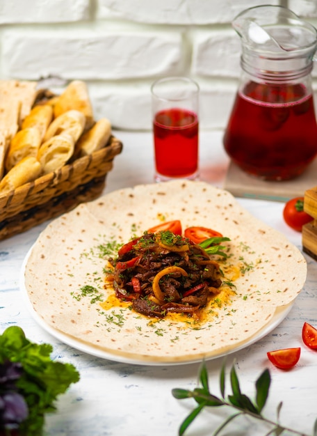 Roasted meat and vegetables with herbs on a white plate with bread vegetables and glass of wine 