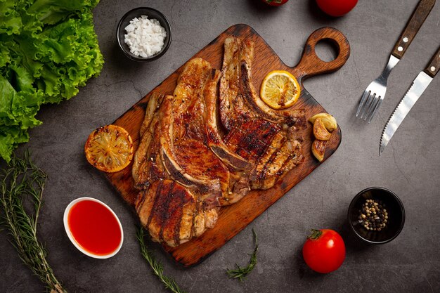 Roasted pork steak on the dark surface.