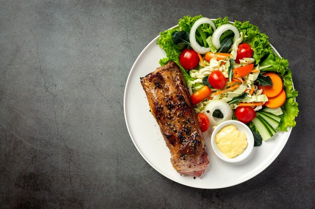 Roasted pork steak and vegetables on plate.