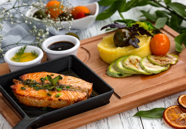 Free Photo roasted salmon steak in cast iron pan served with mashed potato