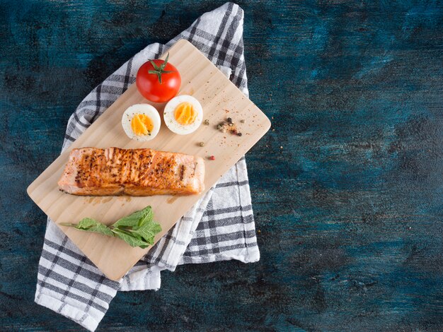 Roasted salmon with boiled egg on board