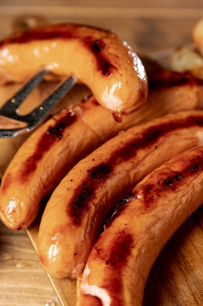 Free Photo roasted sausages with grill fork on a table