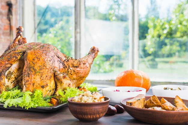 Free photo roasted turkey with dishes on table