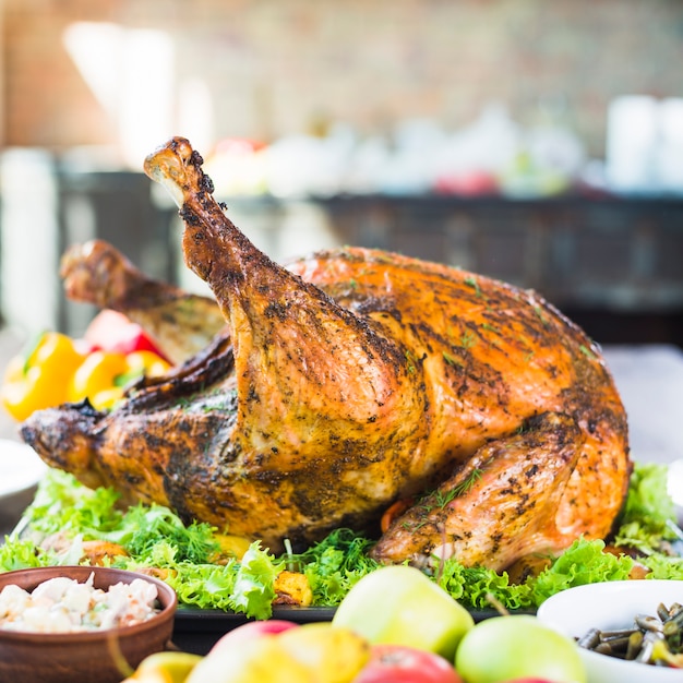 Free photo roasted turkey with food on table