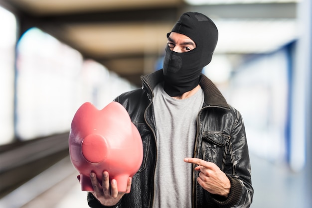 Robber holding a piggybank