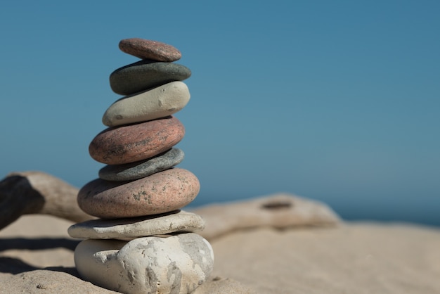 Free photo rocks balanced perfectly on top of each other on sand showing the concept of harmony