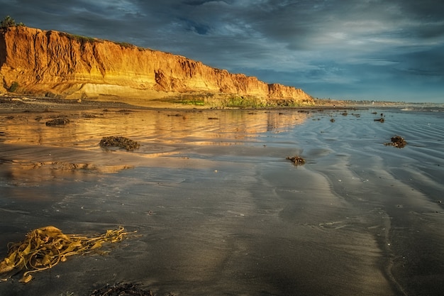 Rocky cliff on the seashore under the beautiful storm clouds