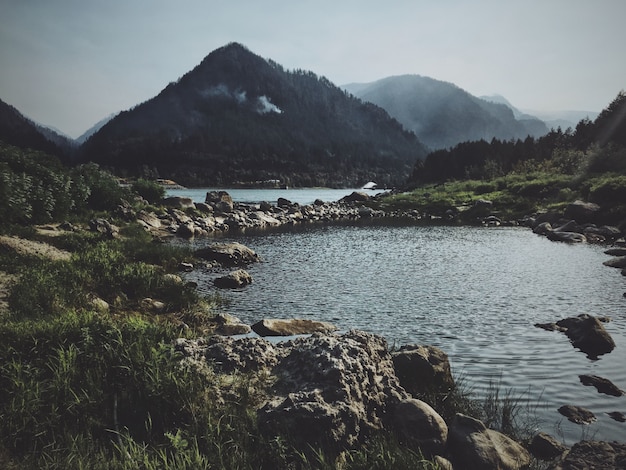 Rocky pathway in the middle of the water with a mountain in the background