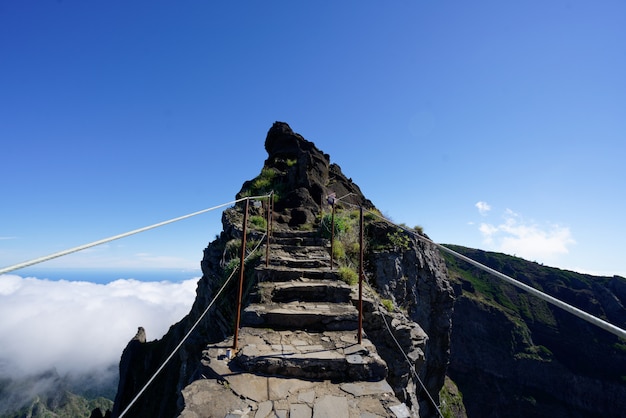 Rocky pathway towards a mountain top with clear sky in the background