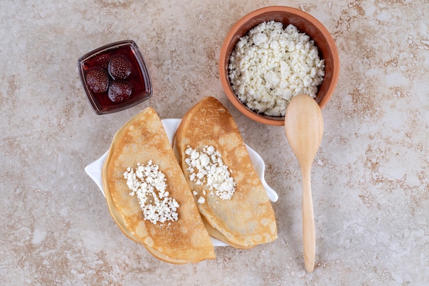 Roll pancakes with cottage cheese and strawberry jam