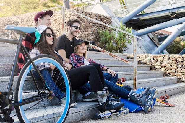 Roller skaters resting near bicycle