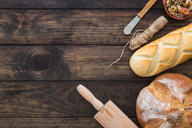 Rolling pin near loaves of bread