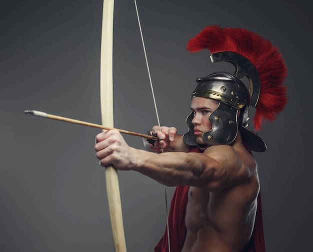 Free Photo roman warrior with bow isolated on a grey background.