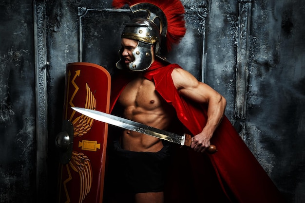 Roman warrior with muscular body holding sword and shield