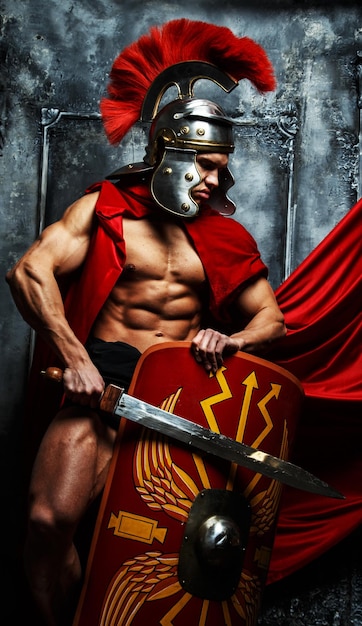 Free photo roman warrior with muscular body holding sword and shield