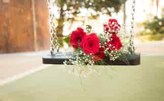 Free photo romantic bouquet on swings in park