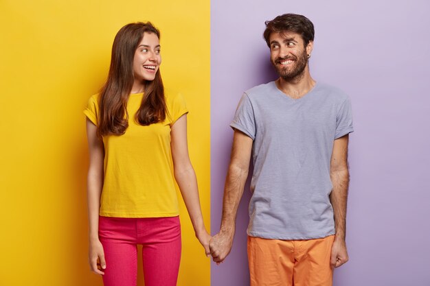 Romantic couple in love have date, hold hands, look positively at each other