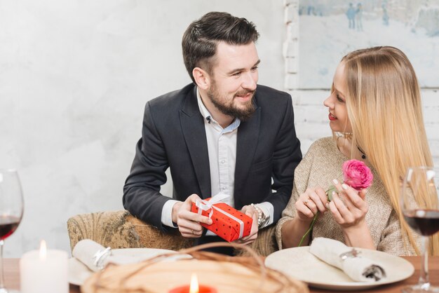 Romantic couple with present and rose