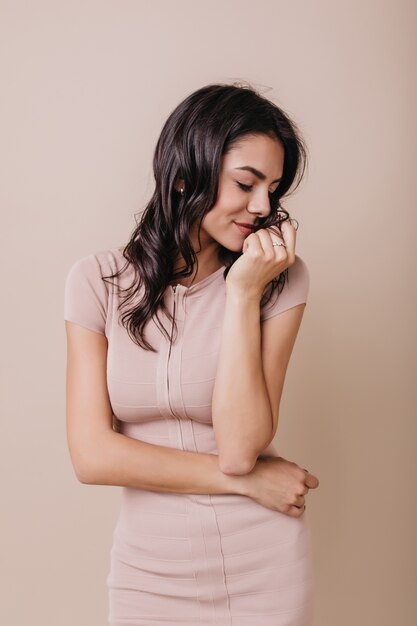 Romantic girl in beautiful dress shyly turns her head. Portrait of brunette in high spirits