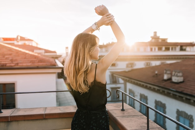 Romantic girl with blonde hair spending time outdoor enjoying sunrise in summer morning