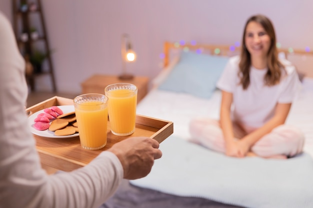 Free photo romantic man brings breakfast to his wife