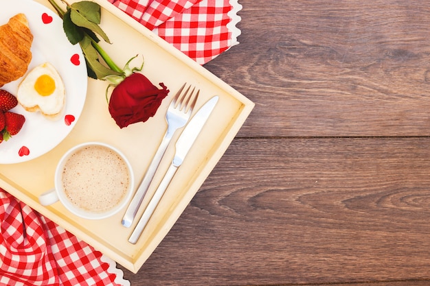 Romantic meal on tray with red rose