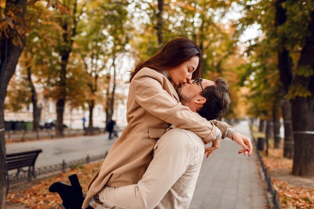 Romantic moments. Happy beautiful couple in love fooling around and having fun in amazing autumn park.