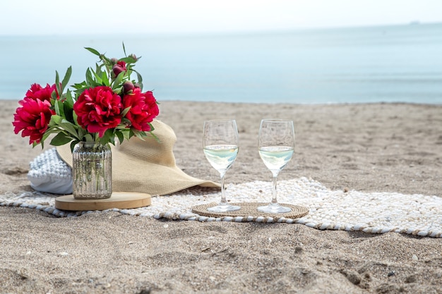 Free photo romantic picnic with flowers and glasses of champagne by the sea. the concept of a holiday.