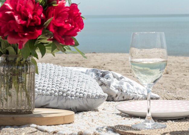 Romantic picnic with flowers and glasses of champagne by the sea. The concept of a holiday.