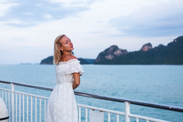 Free Photo romantic portrait of woman in white dress sailing on large boat ferry