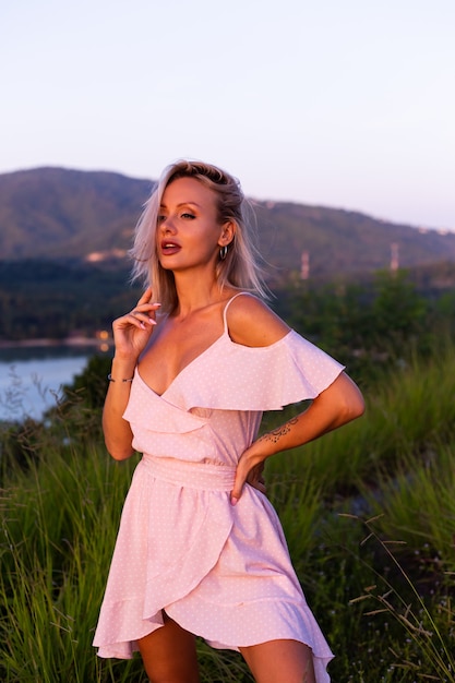 Romantic portrait of young caucasian woman in summer dress enjoying relaxing in park on mountain with amazing tropical sea view Female on vacation travel around Thailand Happy woman at sunset