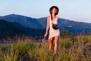 Free photo romantic portrait of young caucasian woman in summer dress enjoying relaxing in park on mountain with amazing tropical sea view female on vacation travel around thailand happy woman at sunset